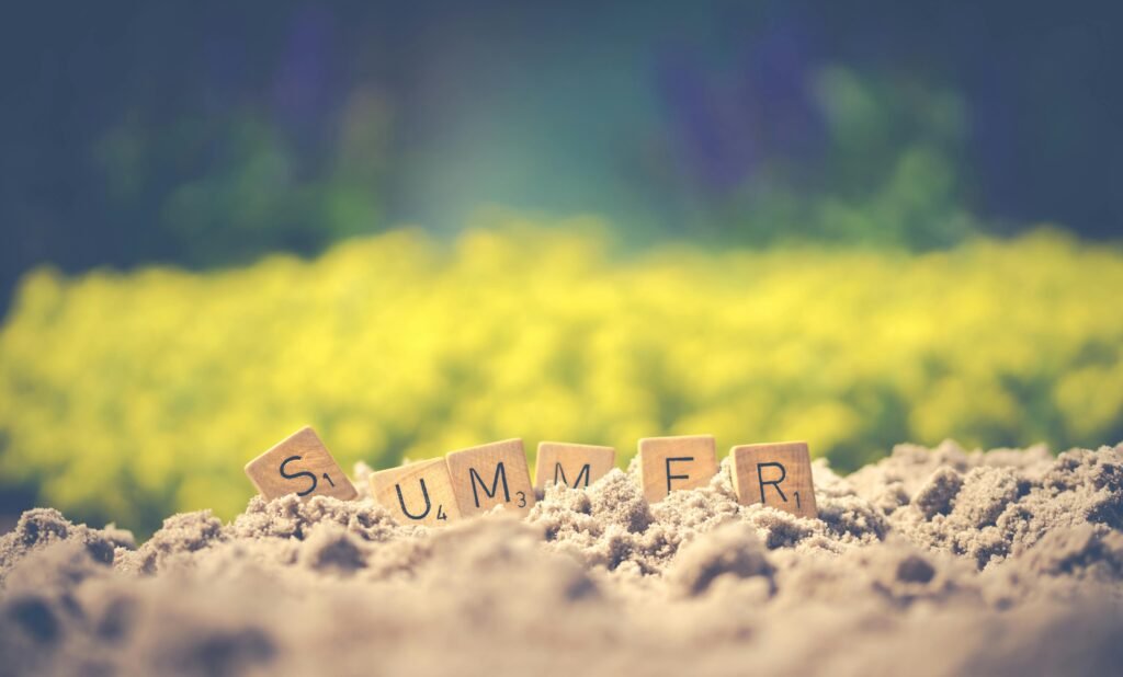"SUMMER" letters in sand with floral background
